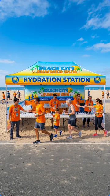 Beach City hydration station canopy tent staffed by volunteers
